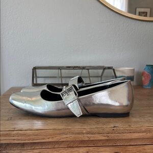 Silver Mary Jane flats with buckle.